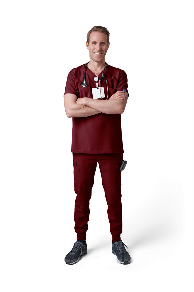 Man wearing MedTailor men's scrub pants in Merlot Red color fabric