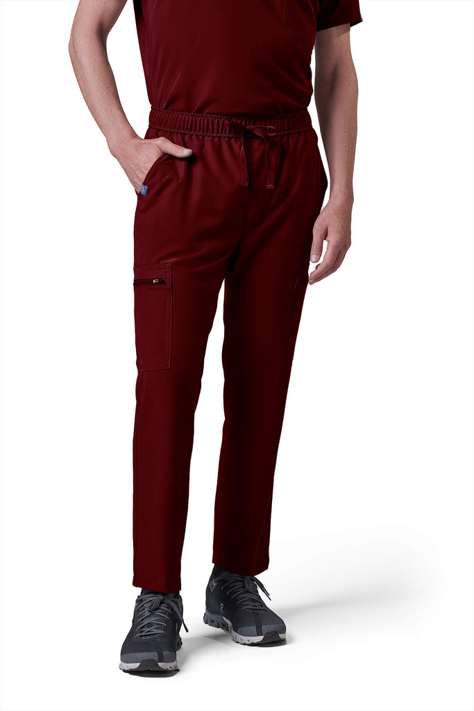 Man wearing MedTailor men's scrub pants in Merlot Red color fabric