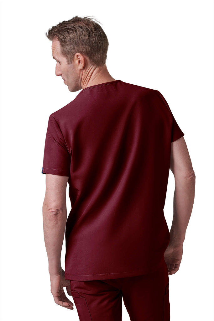 Man wearing MedTailor men's scrub top in Merlot Red color fabric