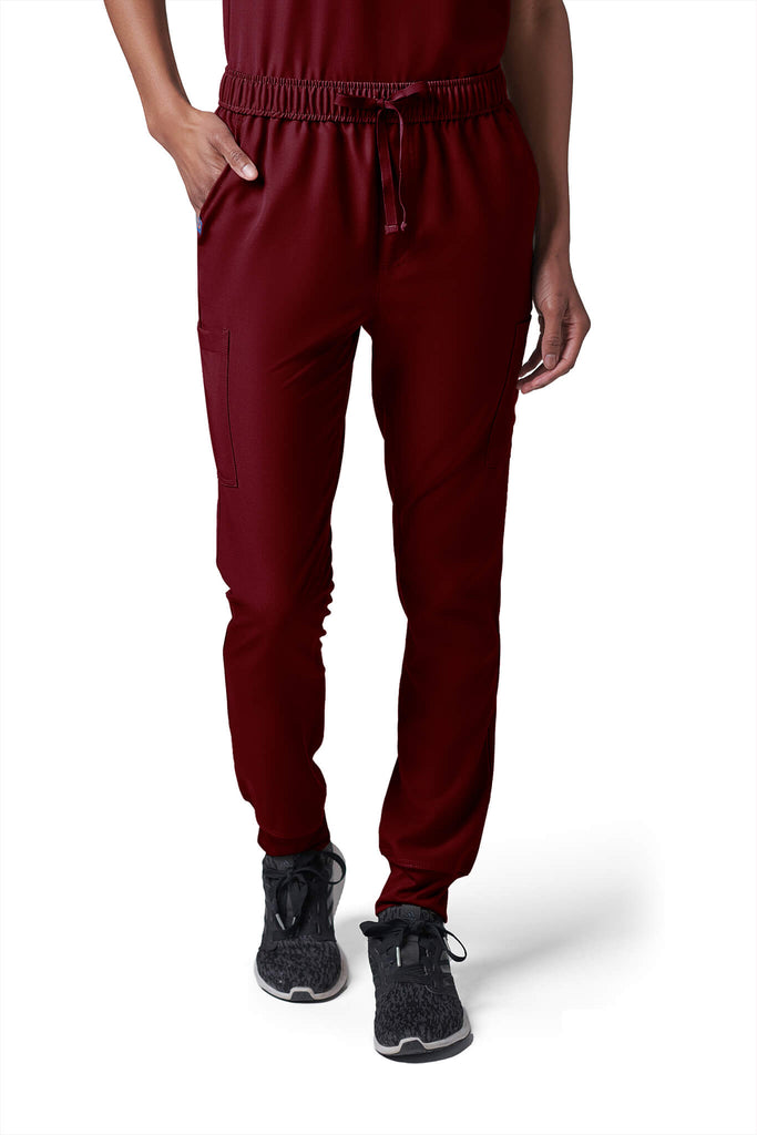 Woman wearing MedTailor women's scrub pants in Merlot Red color fabric